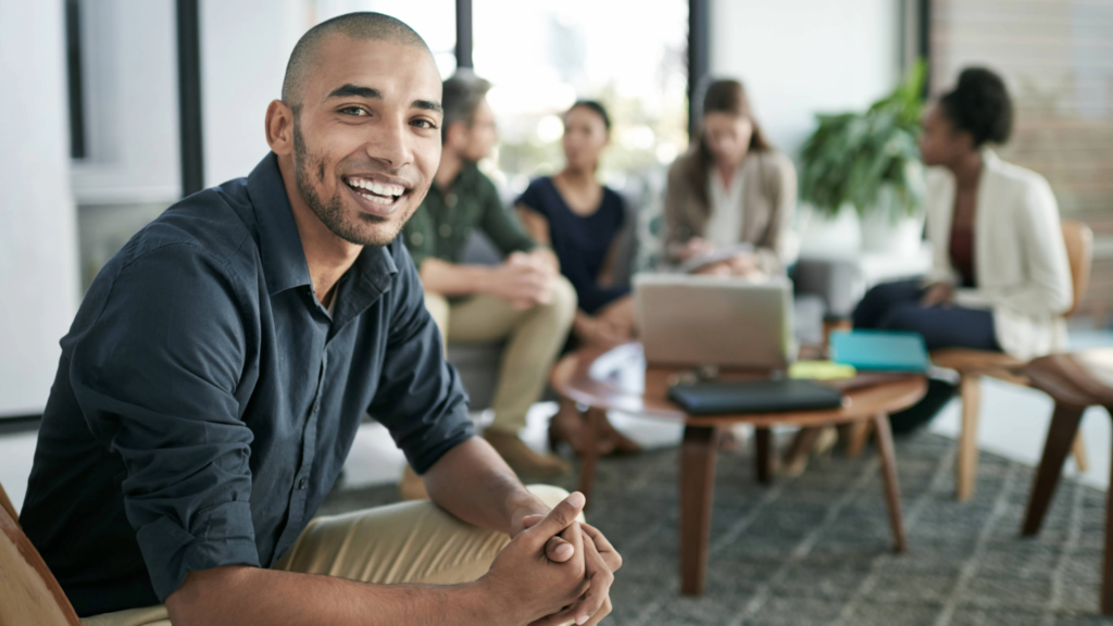 A sales representative observing a team meeting to learn about structural changes.