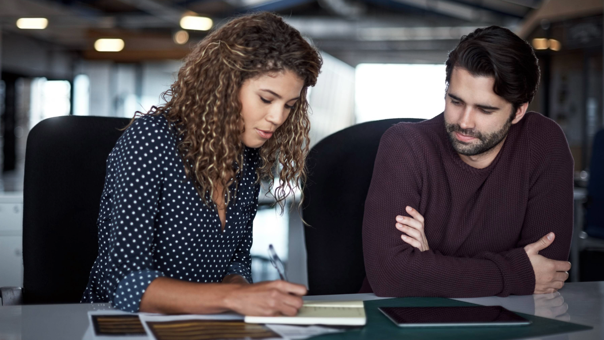 A businesswoman listens to her customer intently during an interview to understand their unique selling proposition.